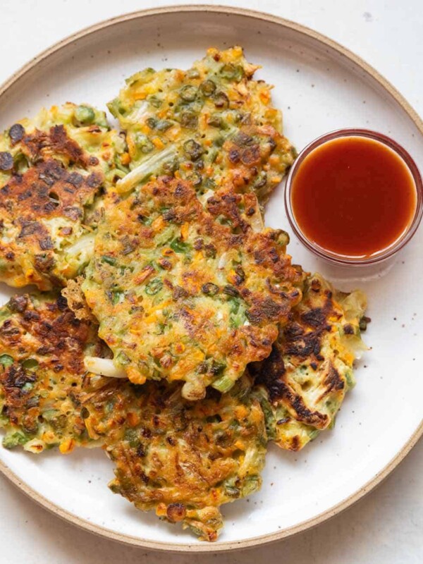 Vegetable pancakes served on a white plate with ketchup on the side