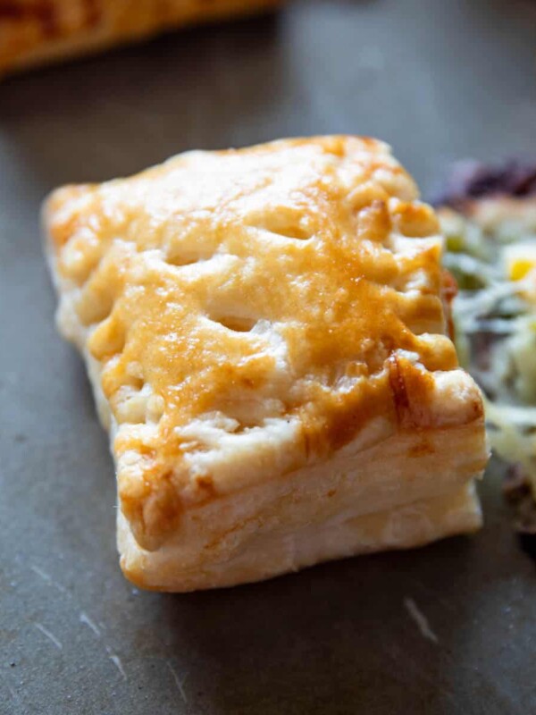 closeup shot of corn spinach puff with the filling oozing out