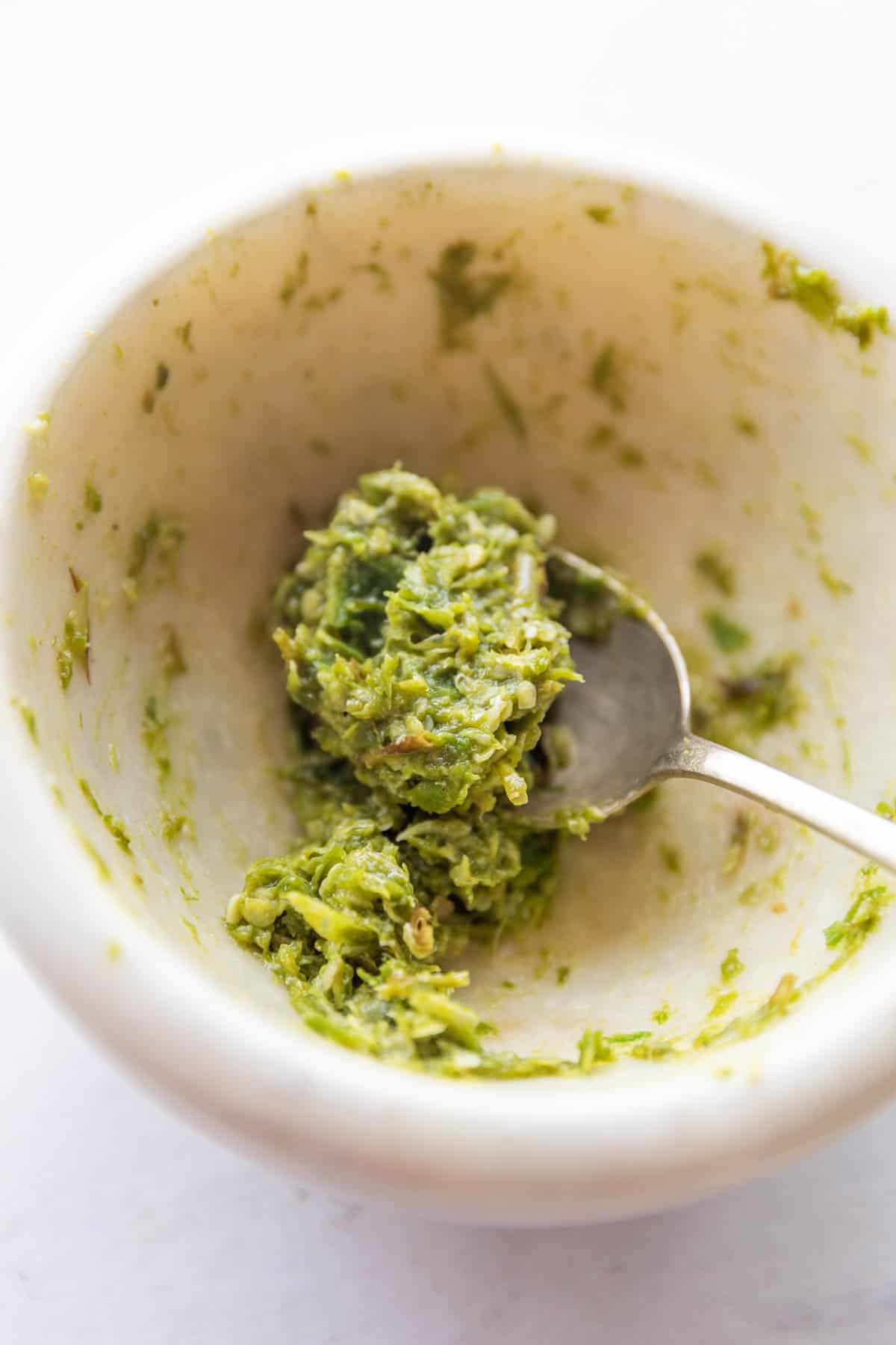 picture of thecha in a white mortar and pestle bowl with a spoon