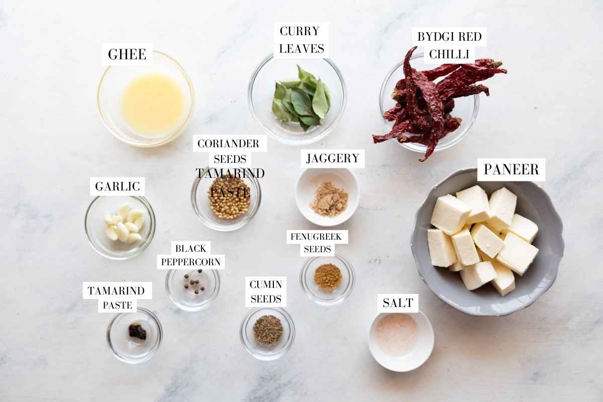 paneer ghee roast ingredients laid out on a white surface with text overlay