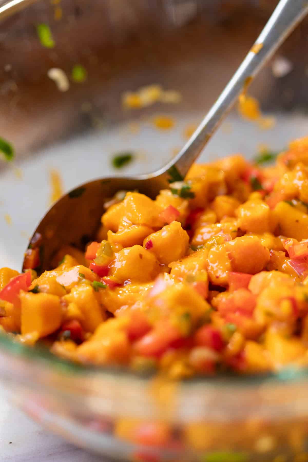 fresh and juicy mango salsa being mixed with with a spoon