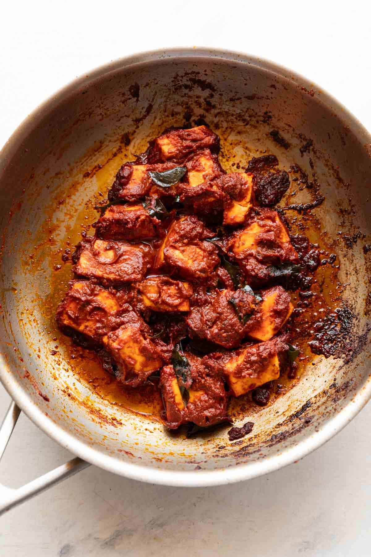 paneer ghee roast being made in a stainless steel pan