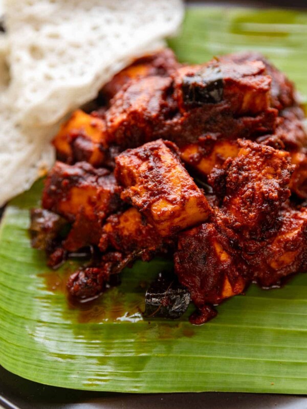 paneer ghee roast served on banana leaf with neer dosa