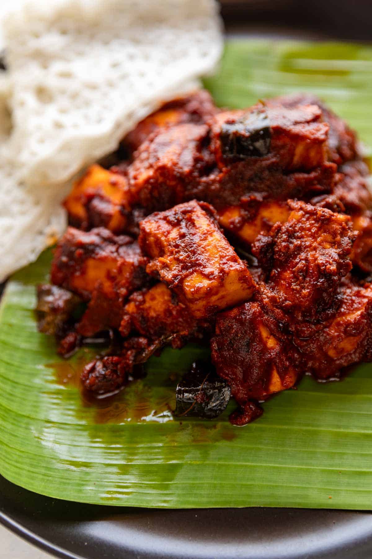 paneer ghee roast served on banana leaf with neer dosa