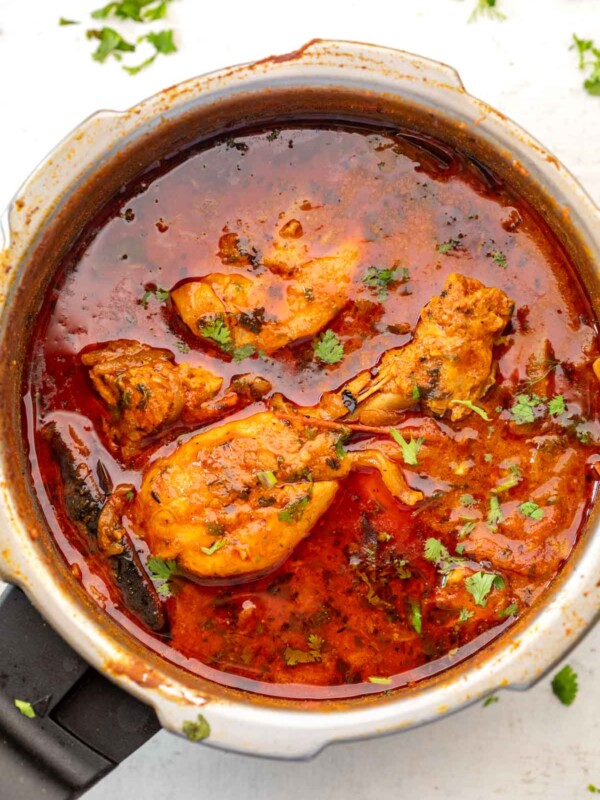 Pressure cooker chicken curry in a pressure cooker on a white background