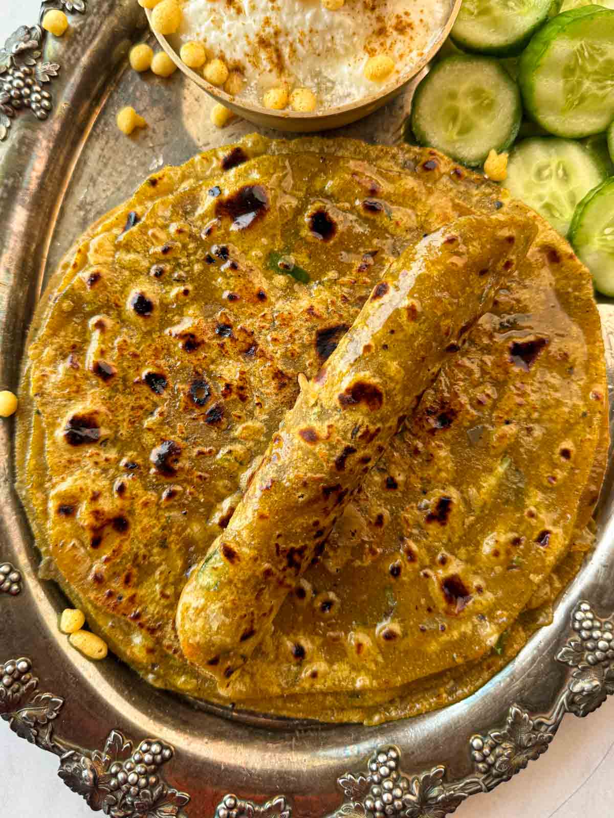 Closeup of dal parathas piled on top of the other with one rolled up