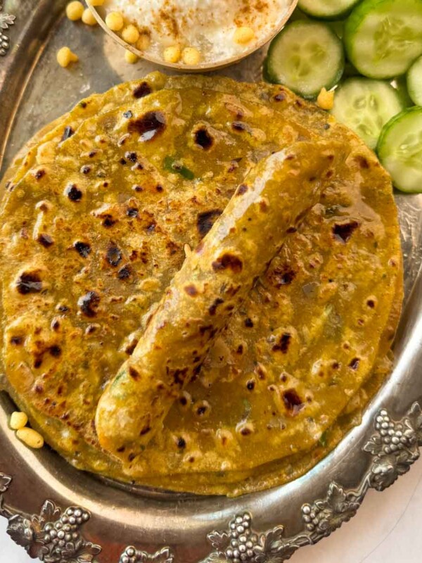 Closeup of dal parathas piled on top of the other with one rolled up