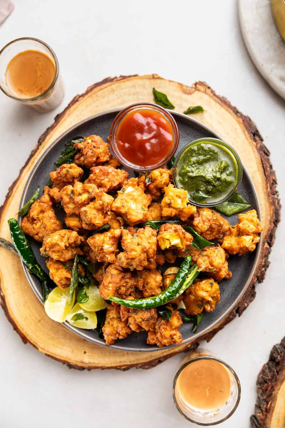 egg pakoda served with green chutney, tomato ketchup, tea fried green chilli and lemon wedges