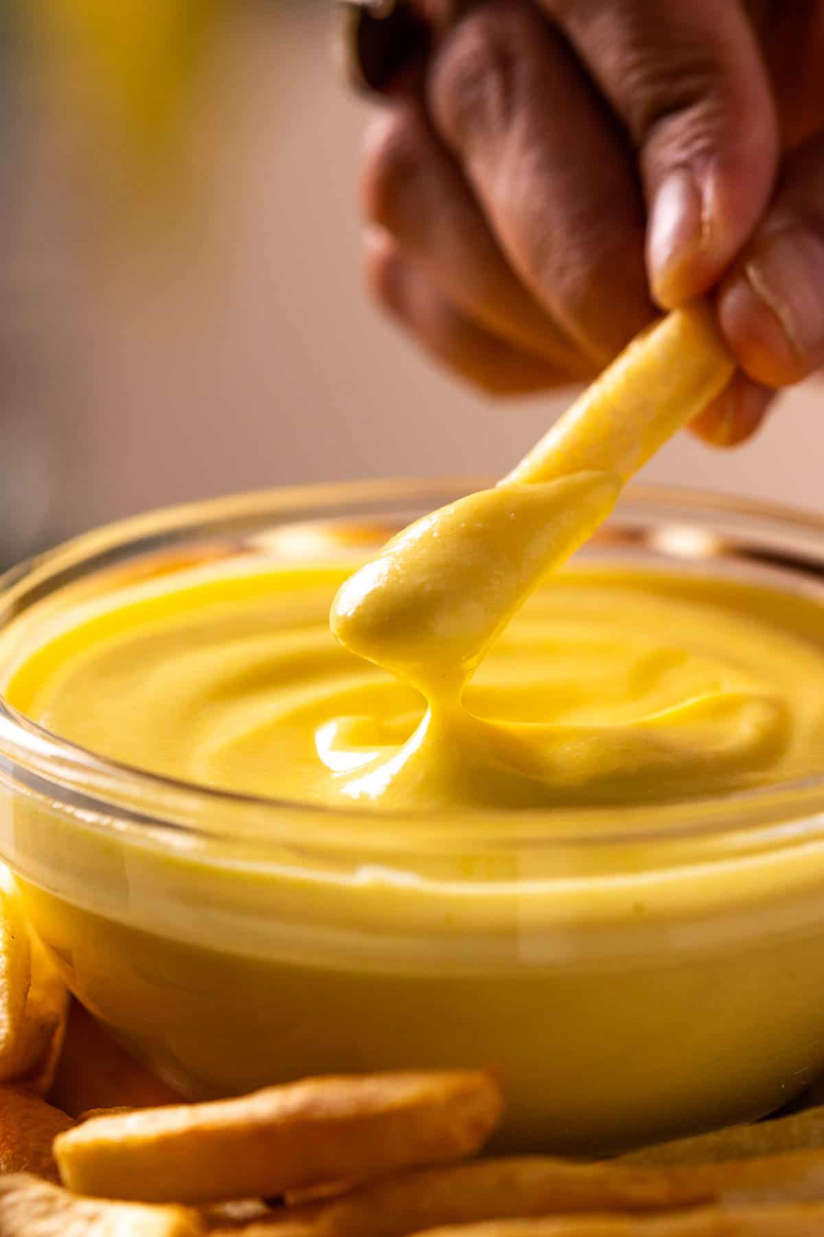 person dipping french fry in boiled egg mayo