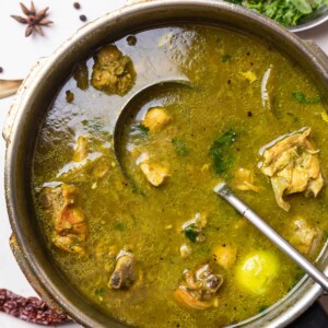 chicken shorba in a pressure cooker with ladle
