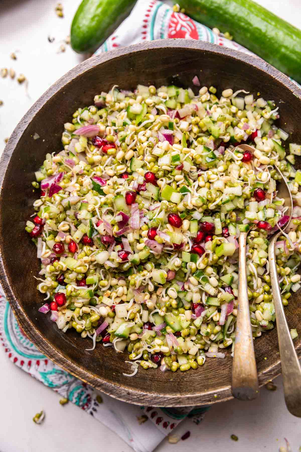moong sprouts & apple salad in a wooden bowl with spoons