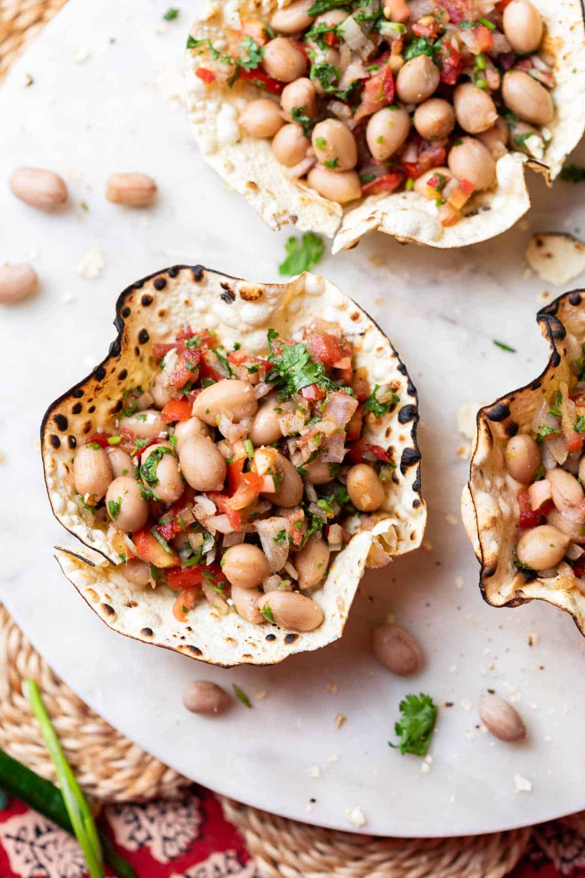 edible papad bowls filled with peanut chaat and served on a white platter
