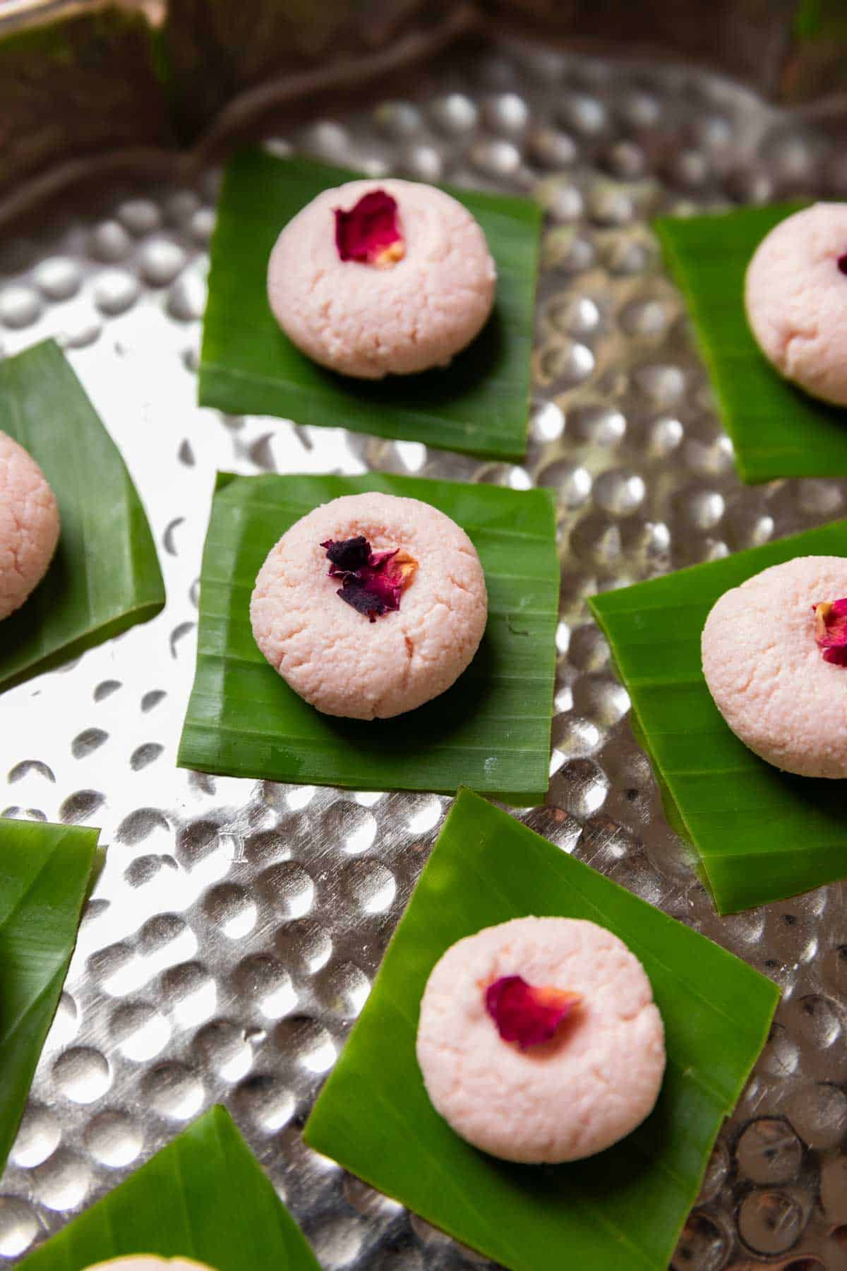 rose kacha gollas garnished with dried rose petal and served on a leaf square