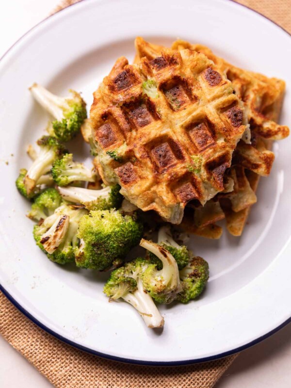 broccoli cheese waffles served on a white plate with a side of roasted broccoli