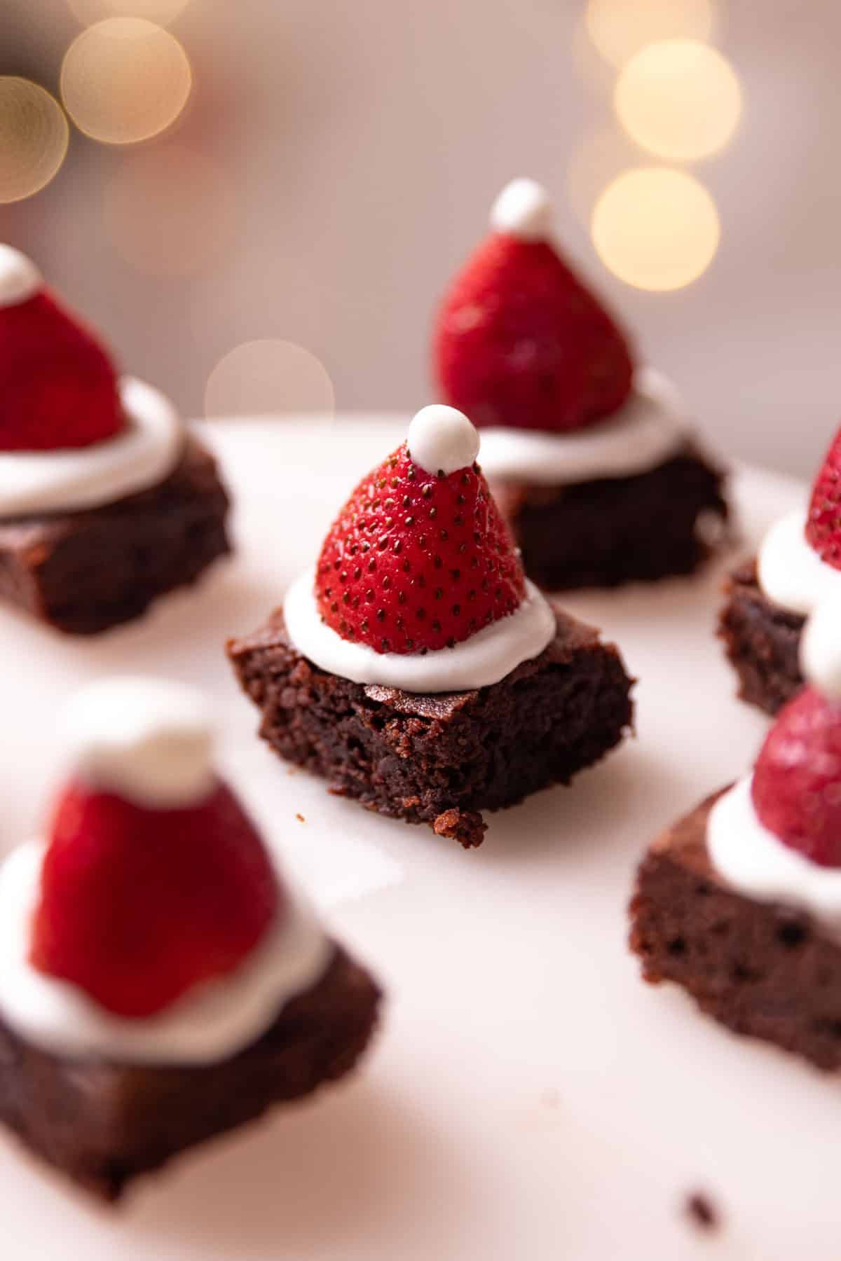 a close up of brownie bites placed on a white platter