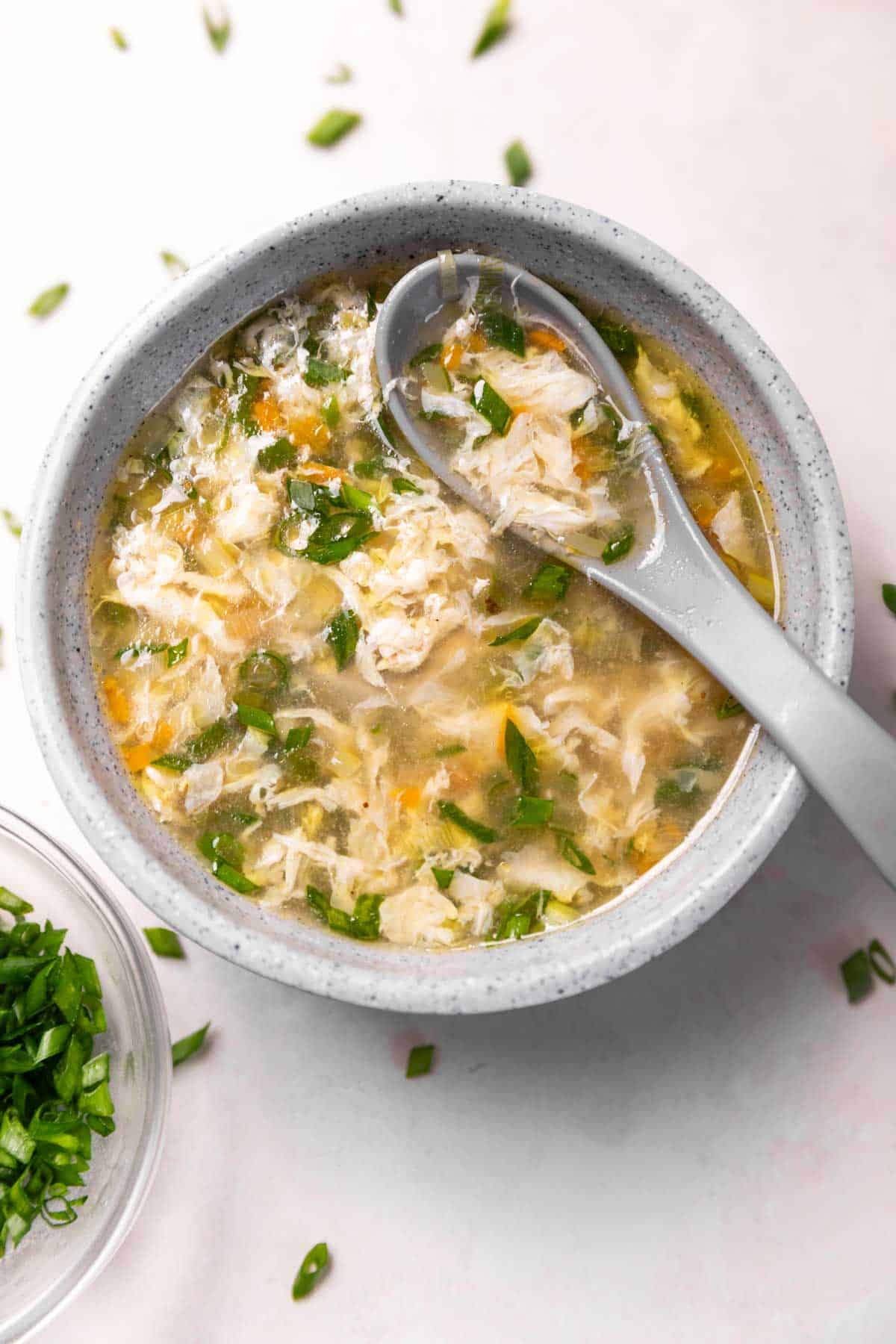 a bowl of egg drop soup with a spoon 