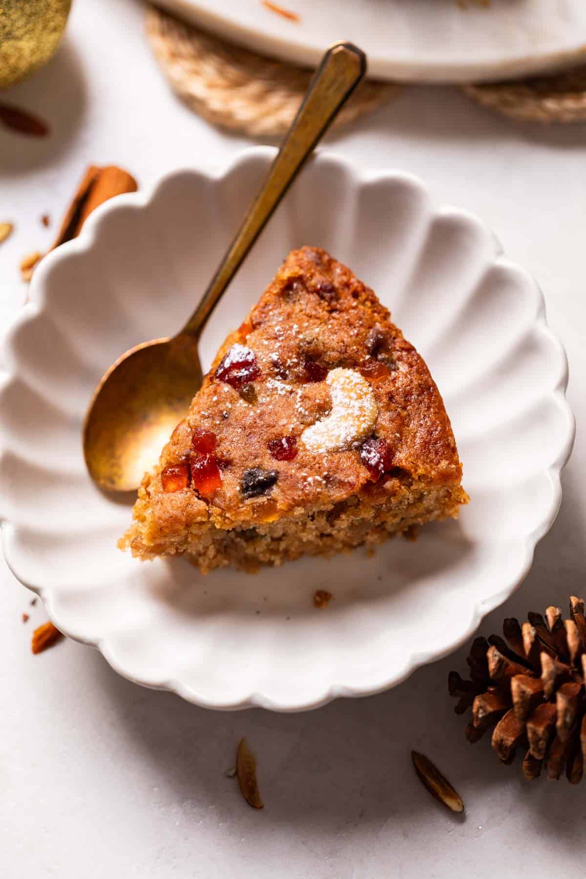 a slice of eggless plum cake in a dish with spoon