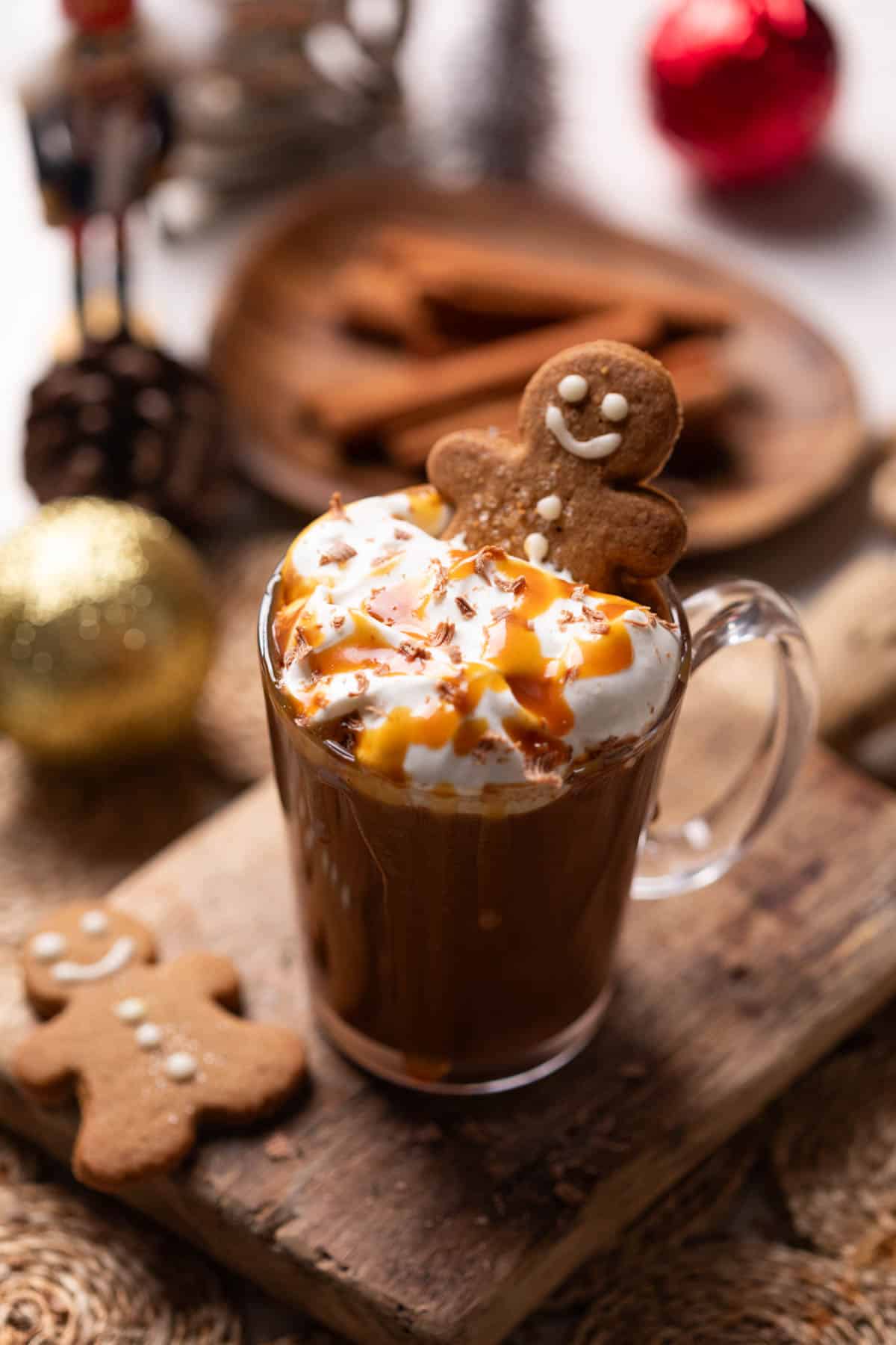 salted caramel hot chocolate served in a mug and topped with whipped cream, caramel sauce and a gingerbread cookie