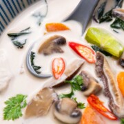 a close up image of vegetarian tom kha soup in a bowl