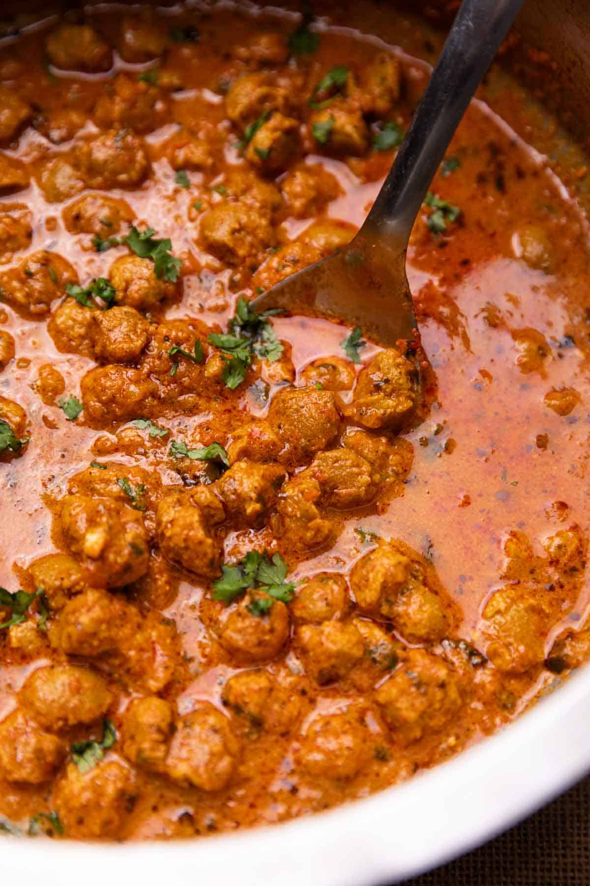 soya curry in a kadai with a ladle