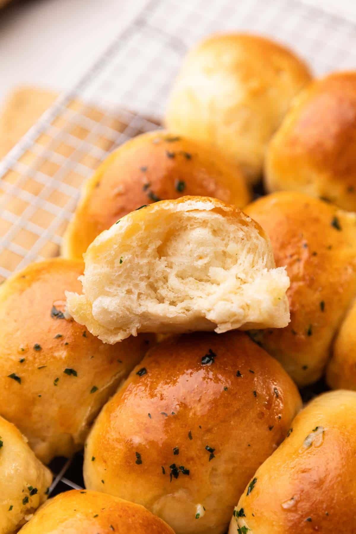 an image of air fryer dinner rolls broken in half to the show the soft and fluffy texture