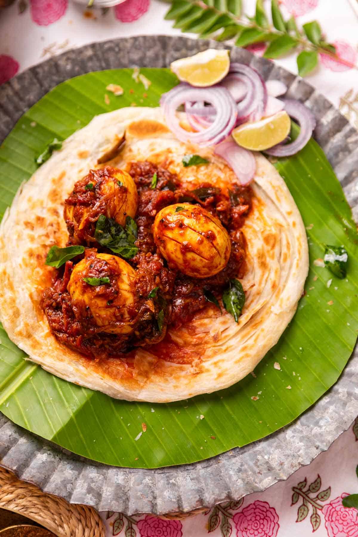 Kerala egg roast served on Malabar Parotta with accompaniments