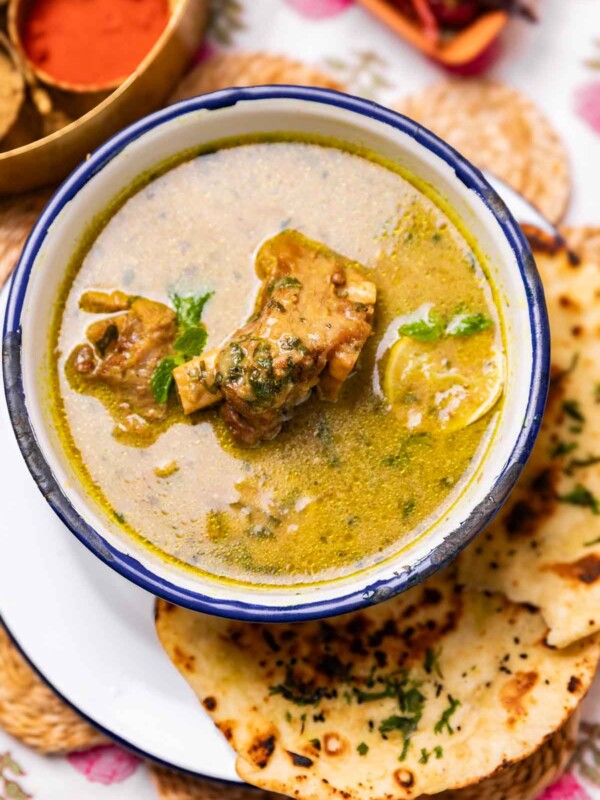 a bowl of mutton marag soup served with accompaniments