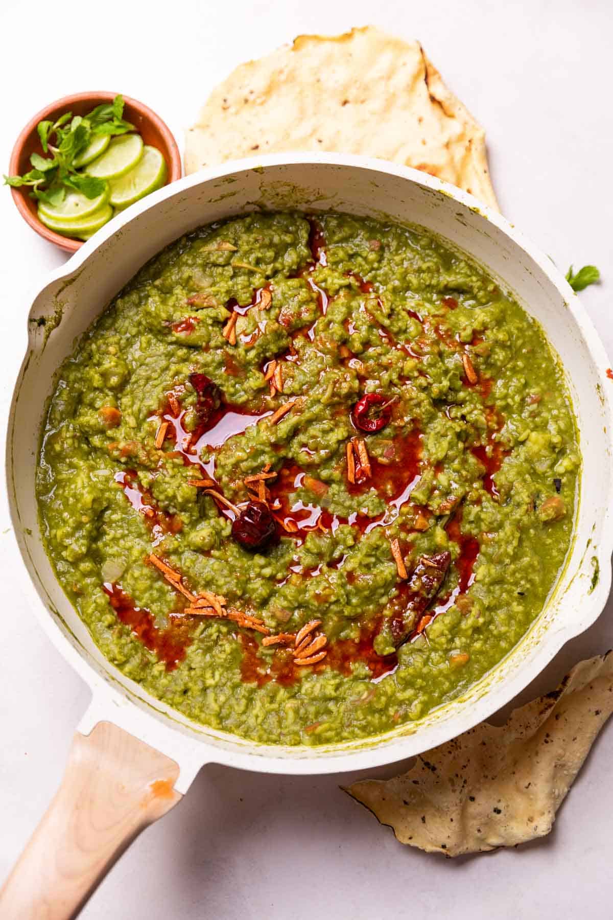 an image of palak khichdi with accompaniments