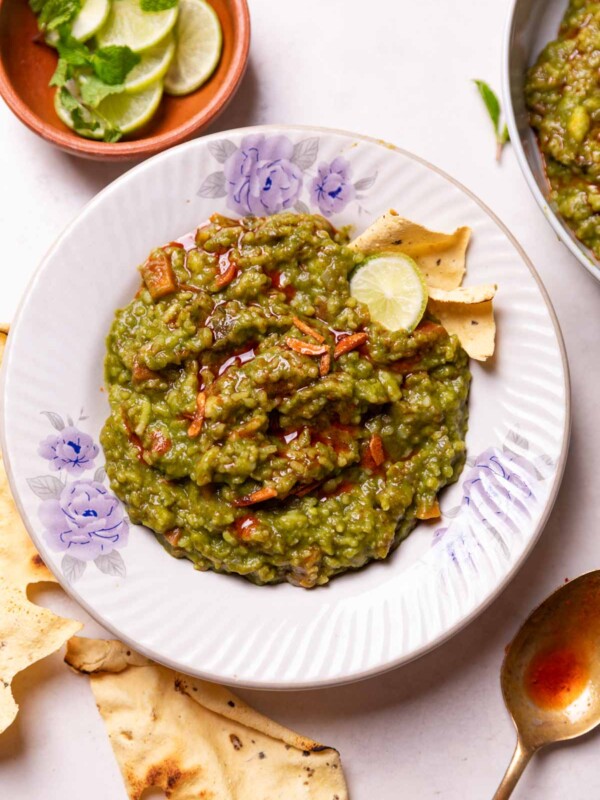palak khichdi served in a bowl with fries and other accompaniments