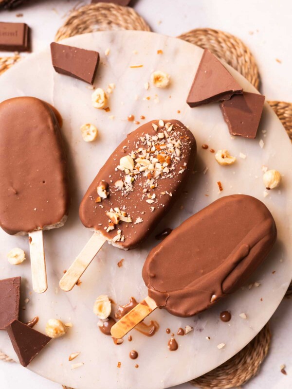 healthy chocobar ice creams garnished with chopped nuts and placed on a white platter