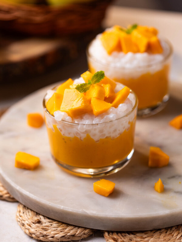 mango sago topped with mango chunks served in a small glass bowls