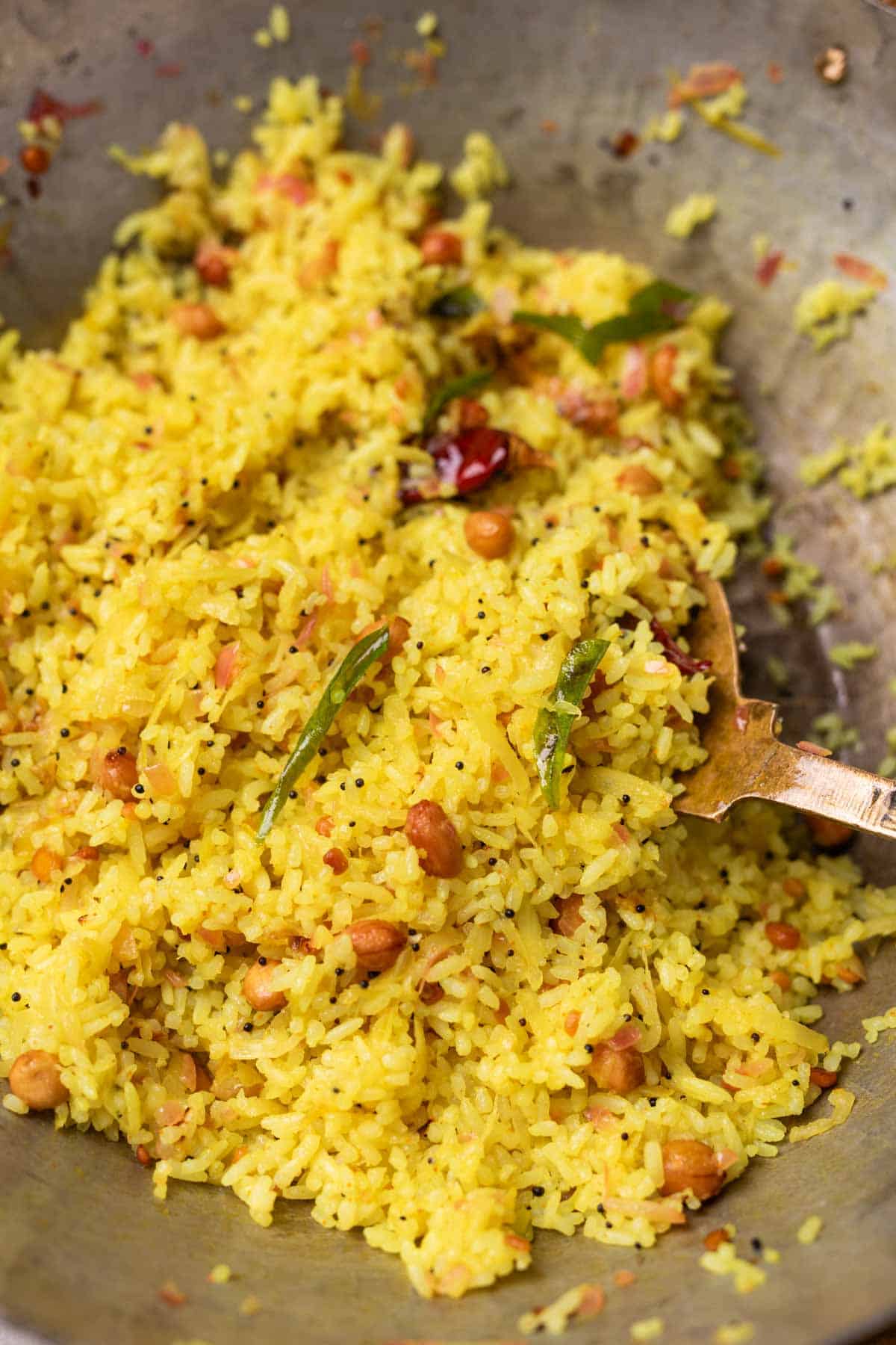 Raw mango rice in a kadai with a ladle