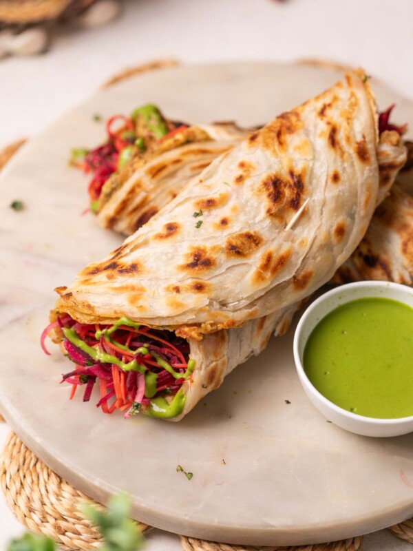 2 anda parathas served on a platter with green chutney