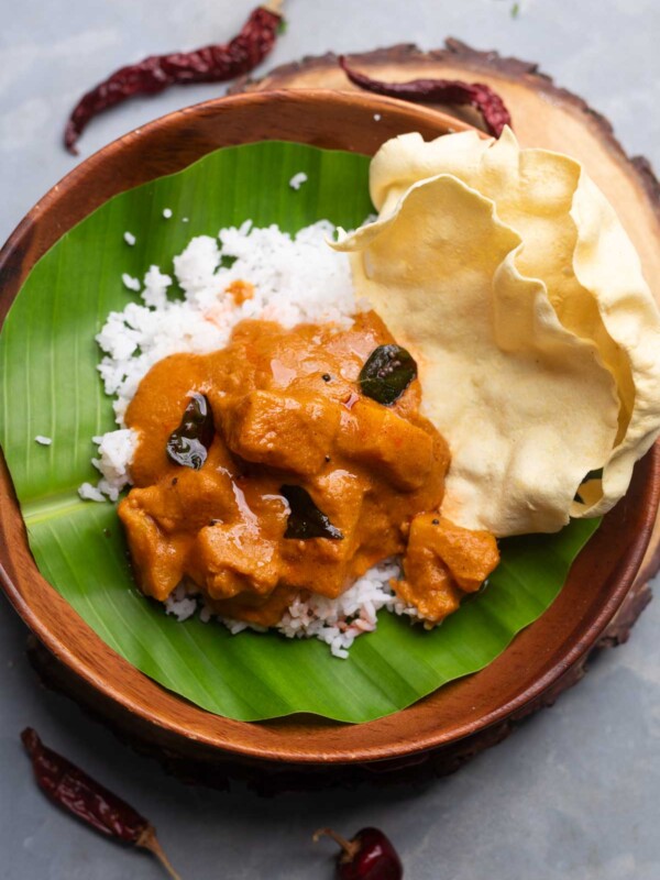 pineapple gojju poured over steamed rice and served with papadum over a banana leaf dish