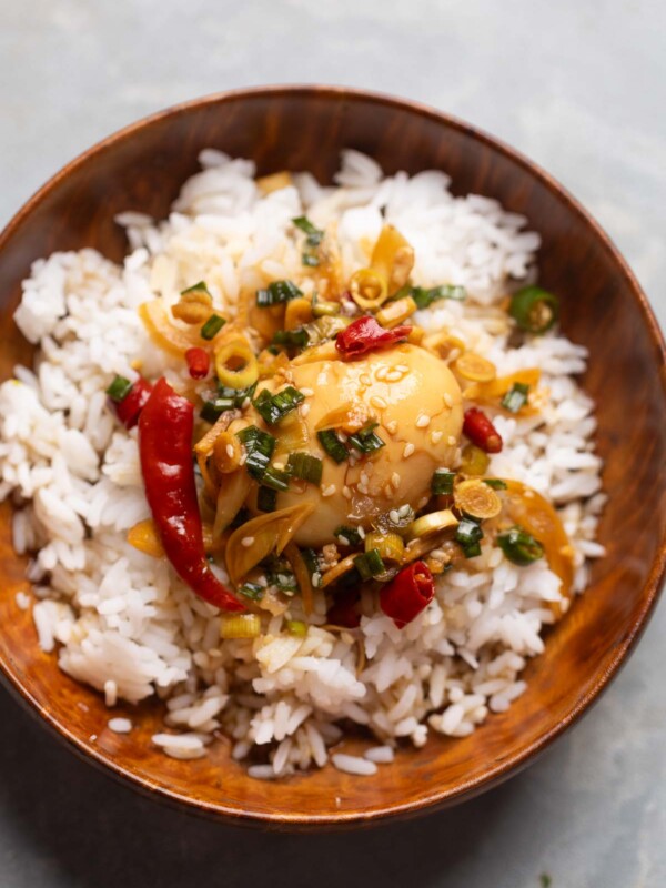 an image of Mayak Eggs poured over steamed rice and served in a wooden bowl with a spoon