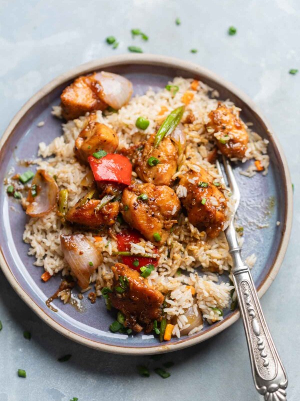 air fryer black pepper chicken poured over rice on a plate