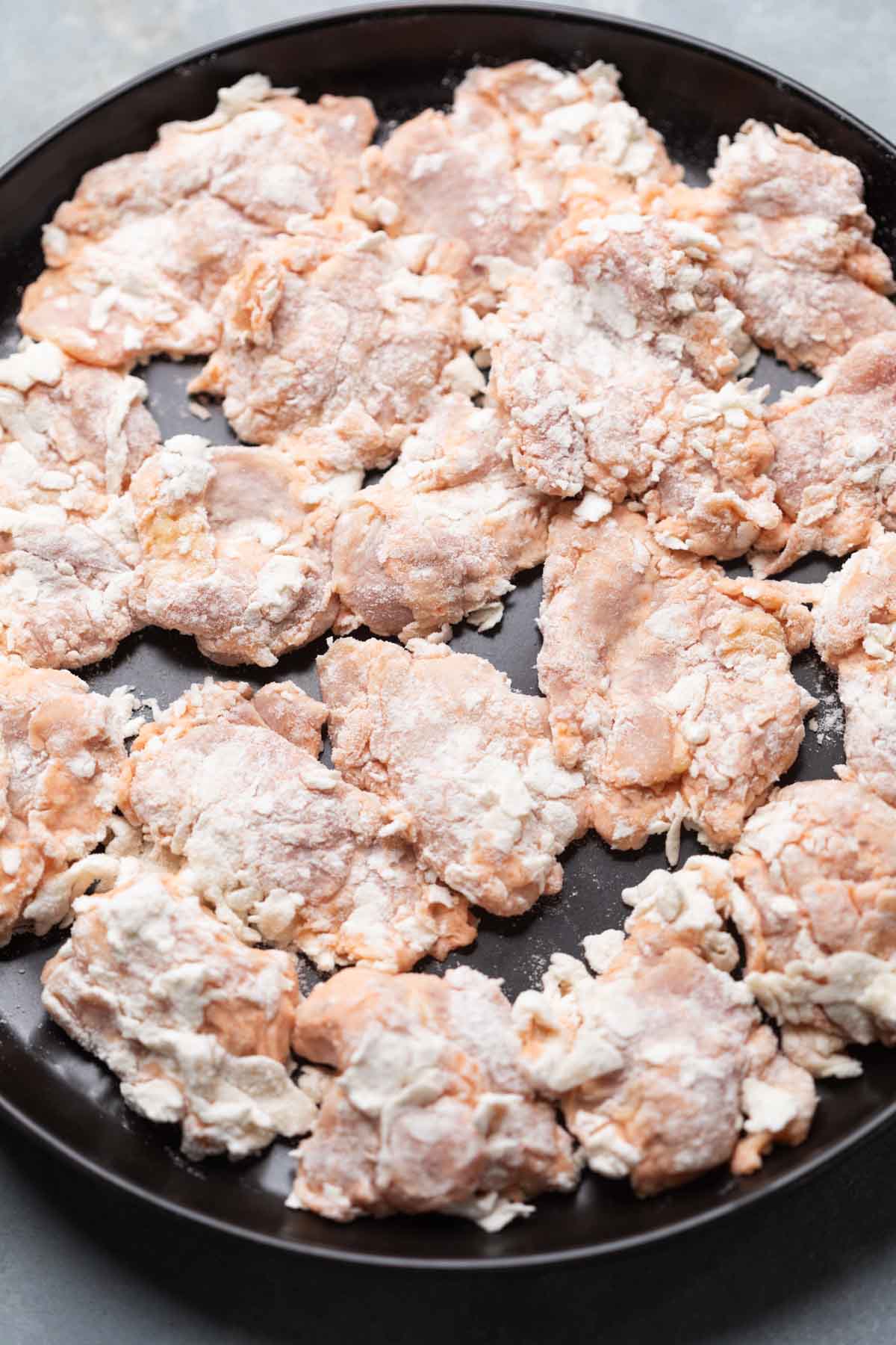 dredged chicken thighs ready to be air fried