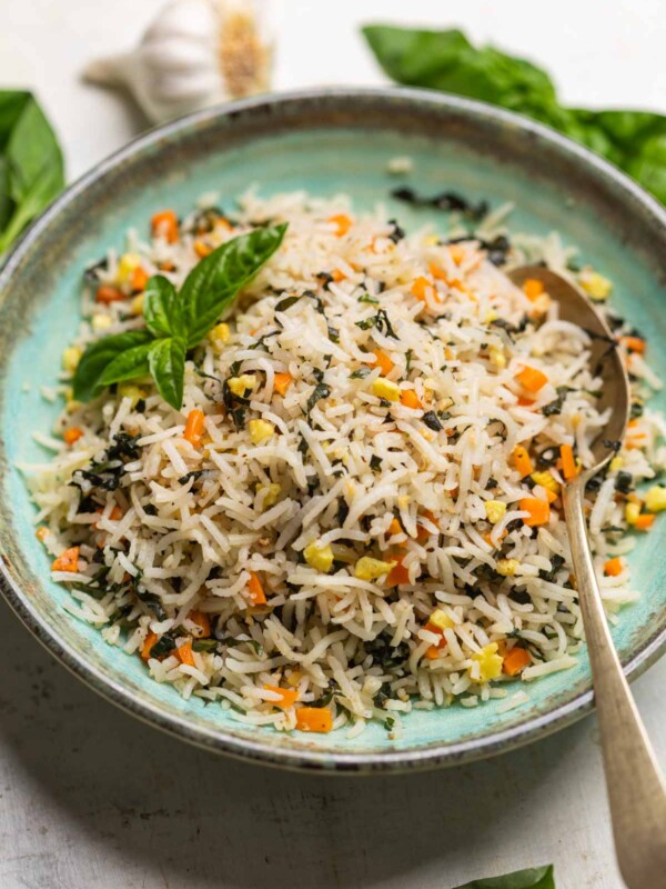 basil fried rice served on a green plate with a spoon