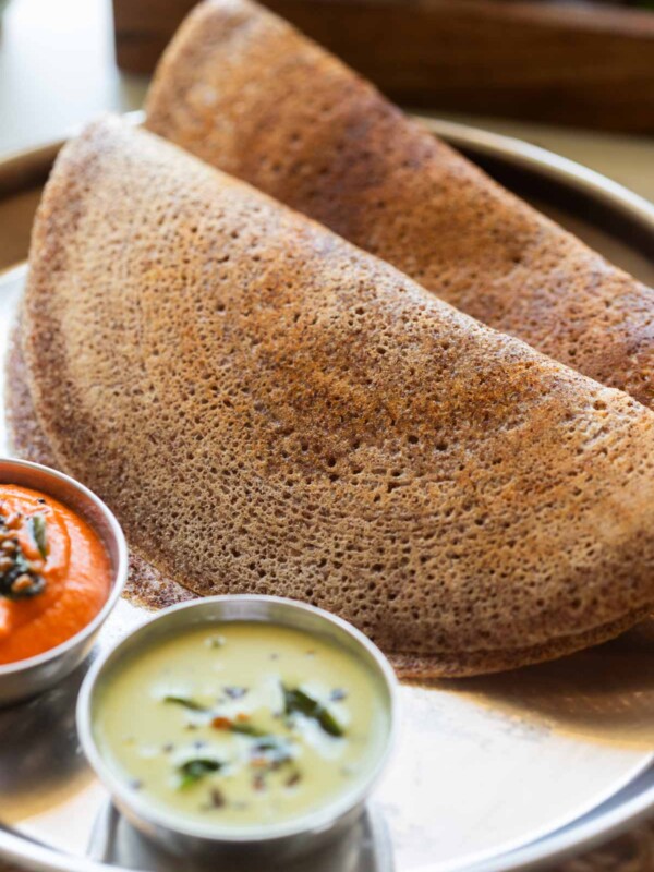 an image of fluffy and crispy ragi dosas served with accompaniments