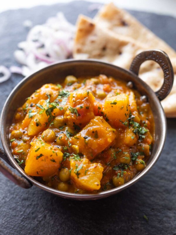 aloo matar sabji served in a bowl with accompaniments