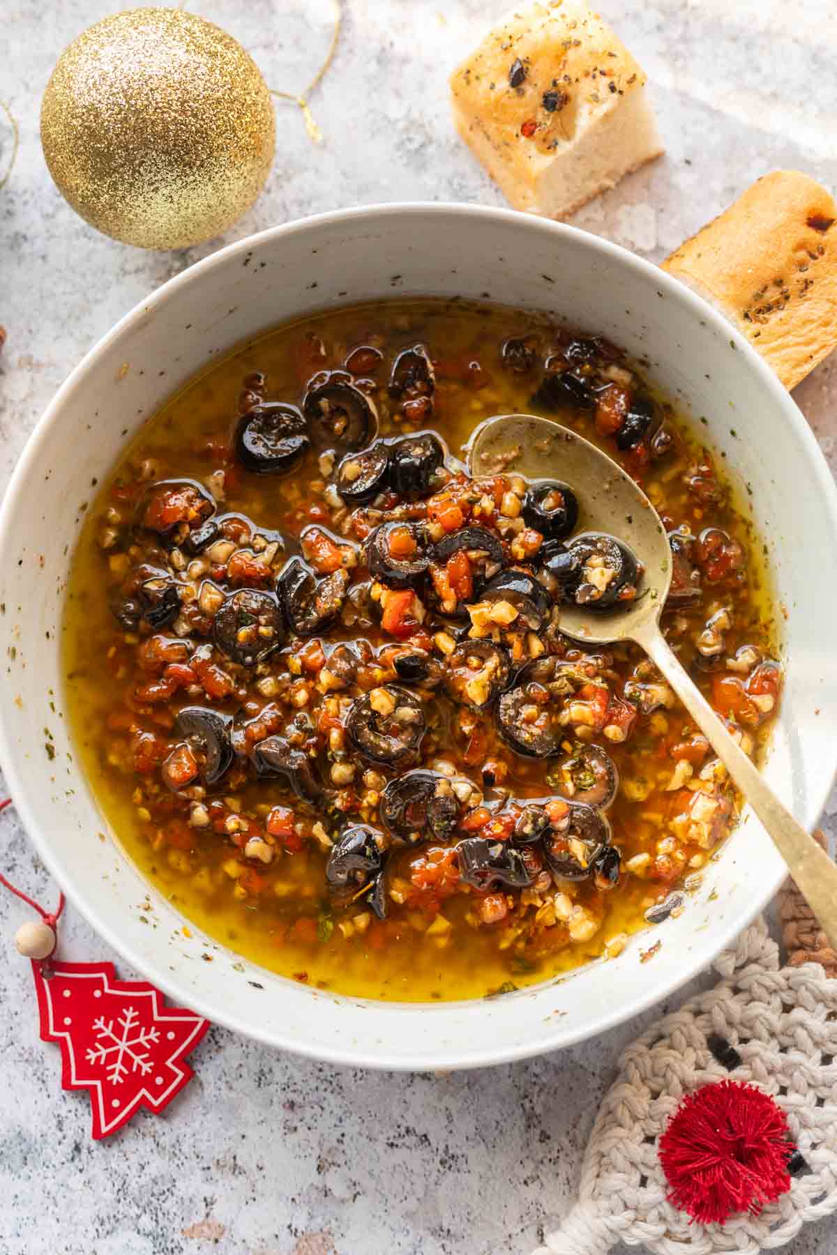 bread dipping oil served in a white bowl with spoon and accompaniments