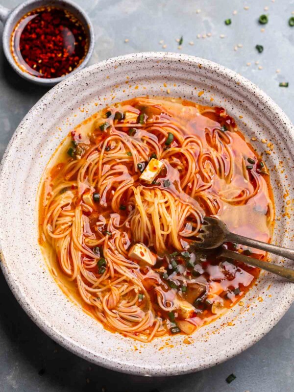 Delicious spicy ramen noodles with tofu, green onions, and chili oil, served in a rustic bowl. Perfect for comforting Asian-inspired meals.