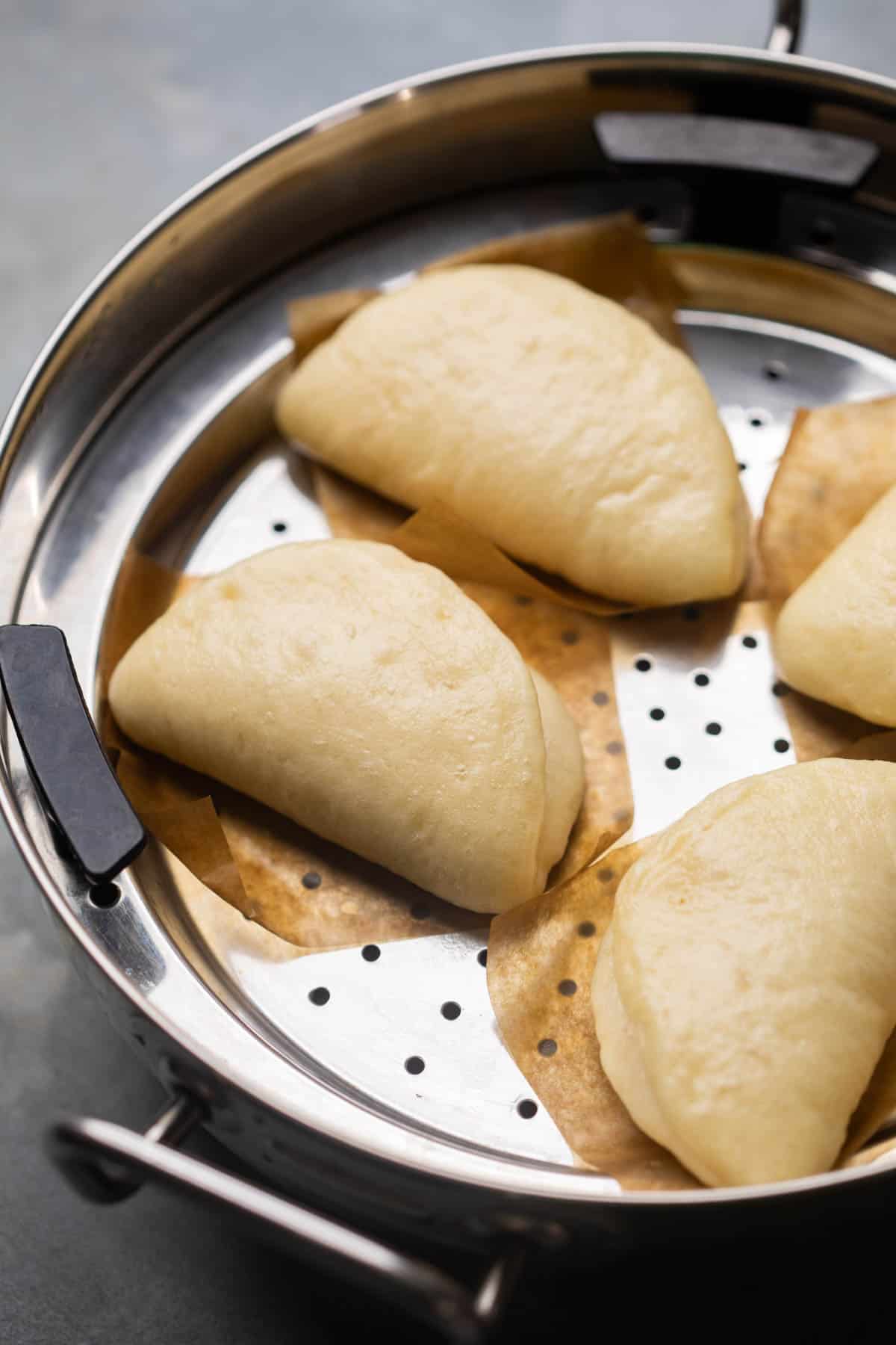 freshly steamed bao buns still in the steamer