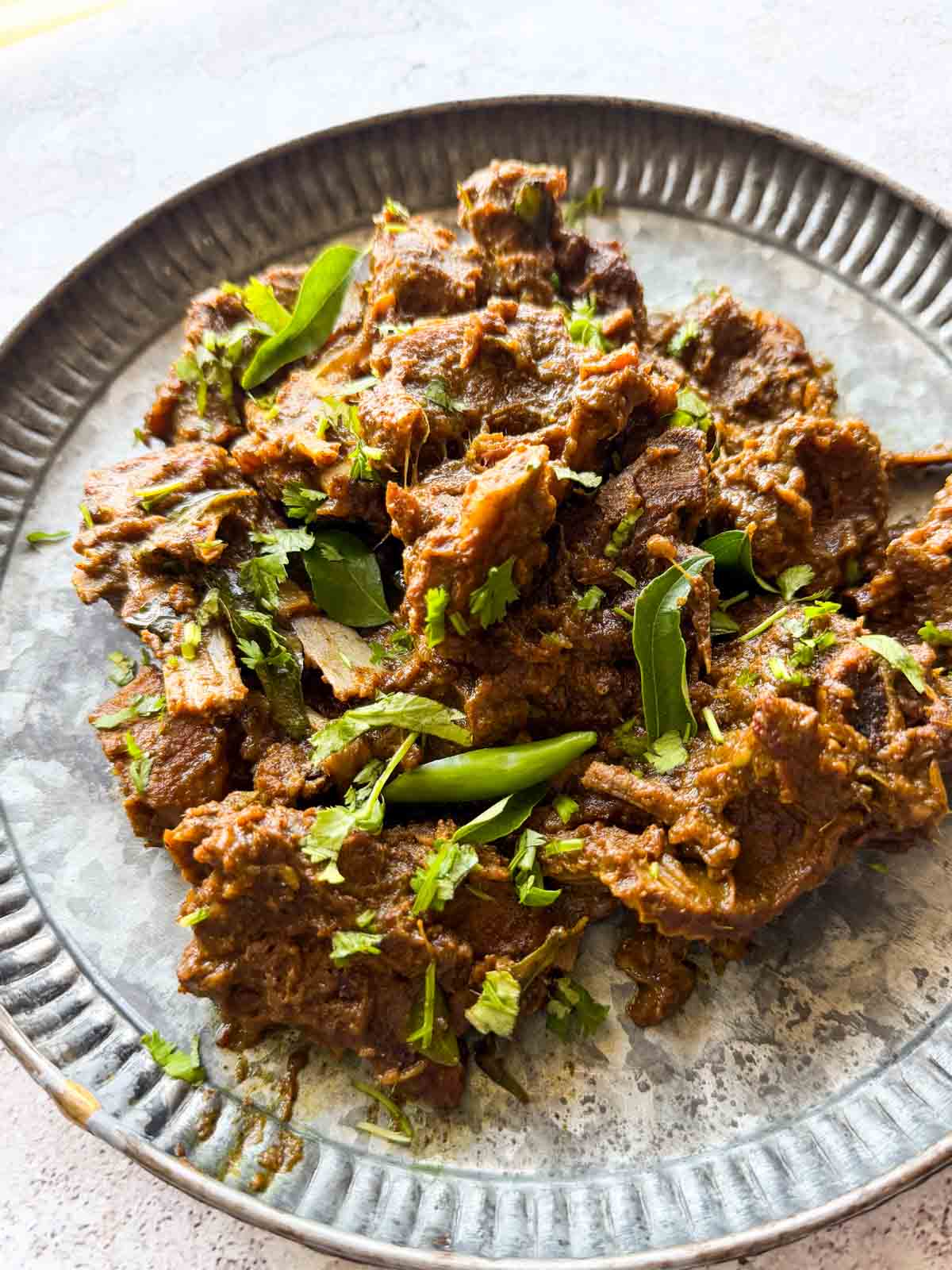 a plate with pepper mutton fry in it